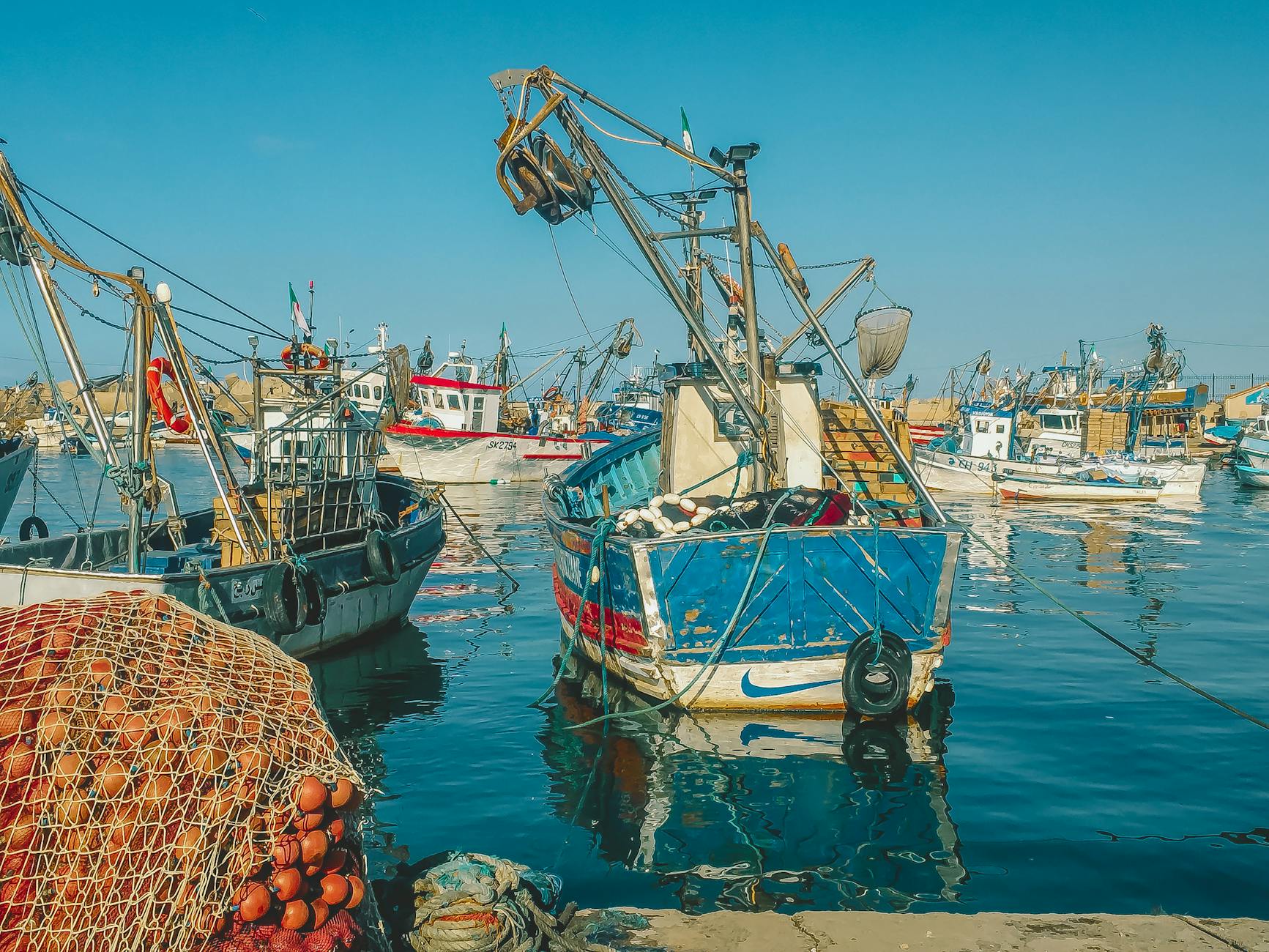 Kolorowe łodzie rybackie zacumowane w spokojnym porcie Bouharoun