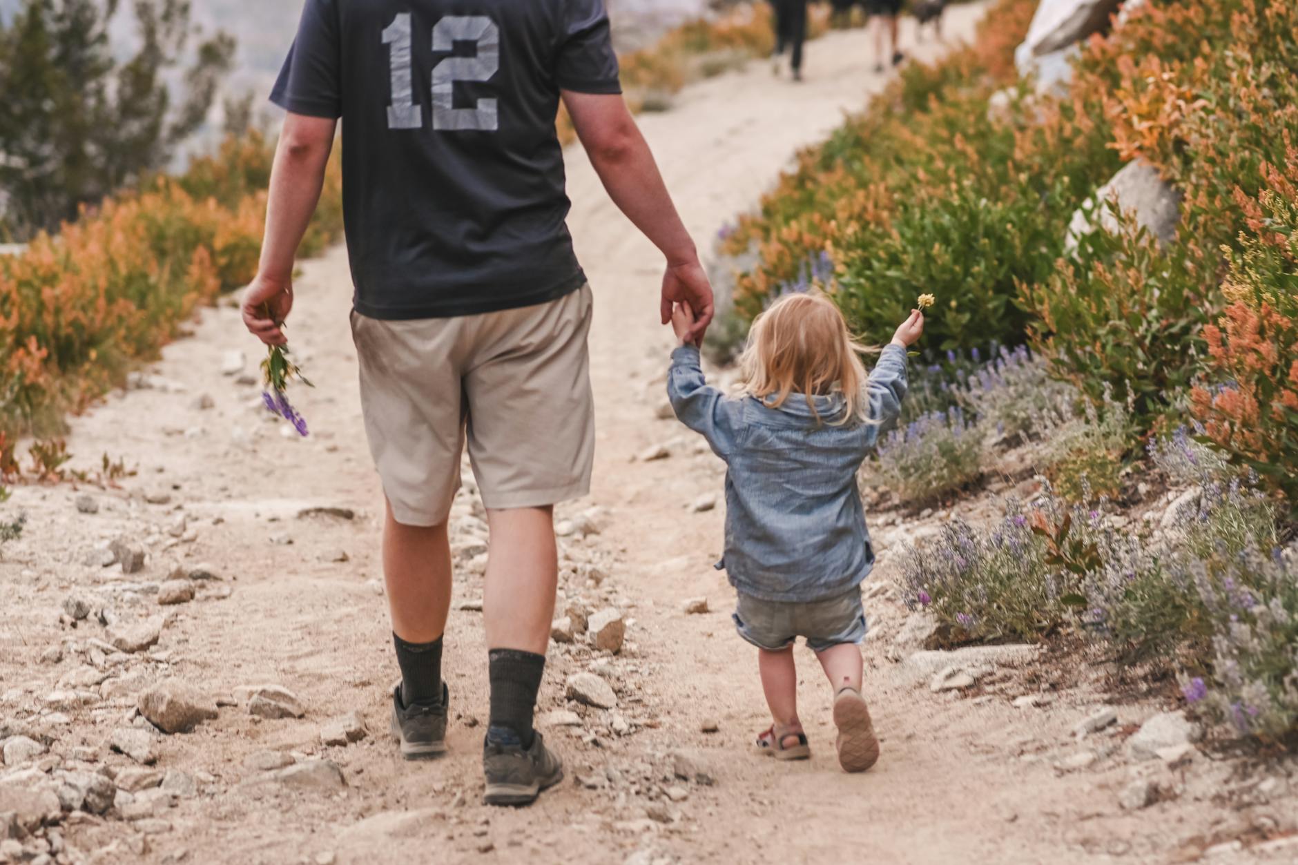 Mikrowyprawa z dzieckiem bez tłumów: dokąd jechać i jak skrócić logistykę Ojciec i córka na letnim górskim szlaku podczas spokojnej wędrówki