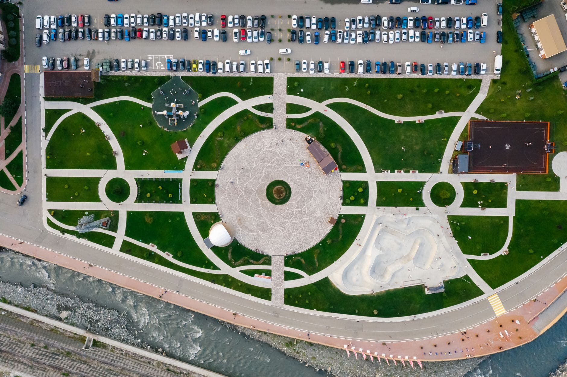Widok z drona na miejski park z dużym parkingiem w tle